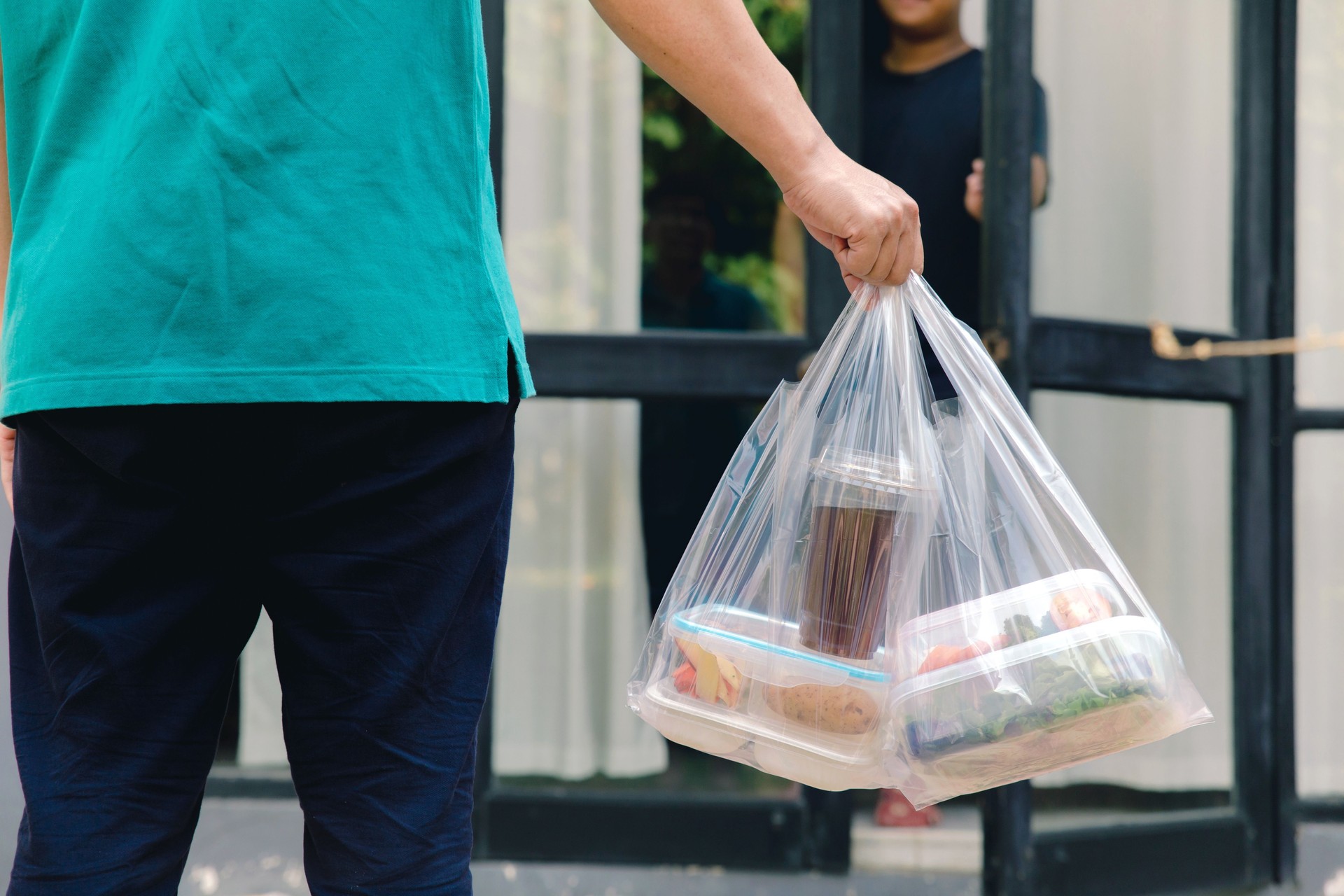 food boxes in plastic bags delivered to customer at home by delivery man .delivery service during covid19