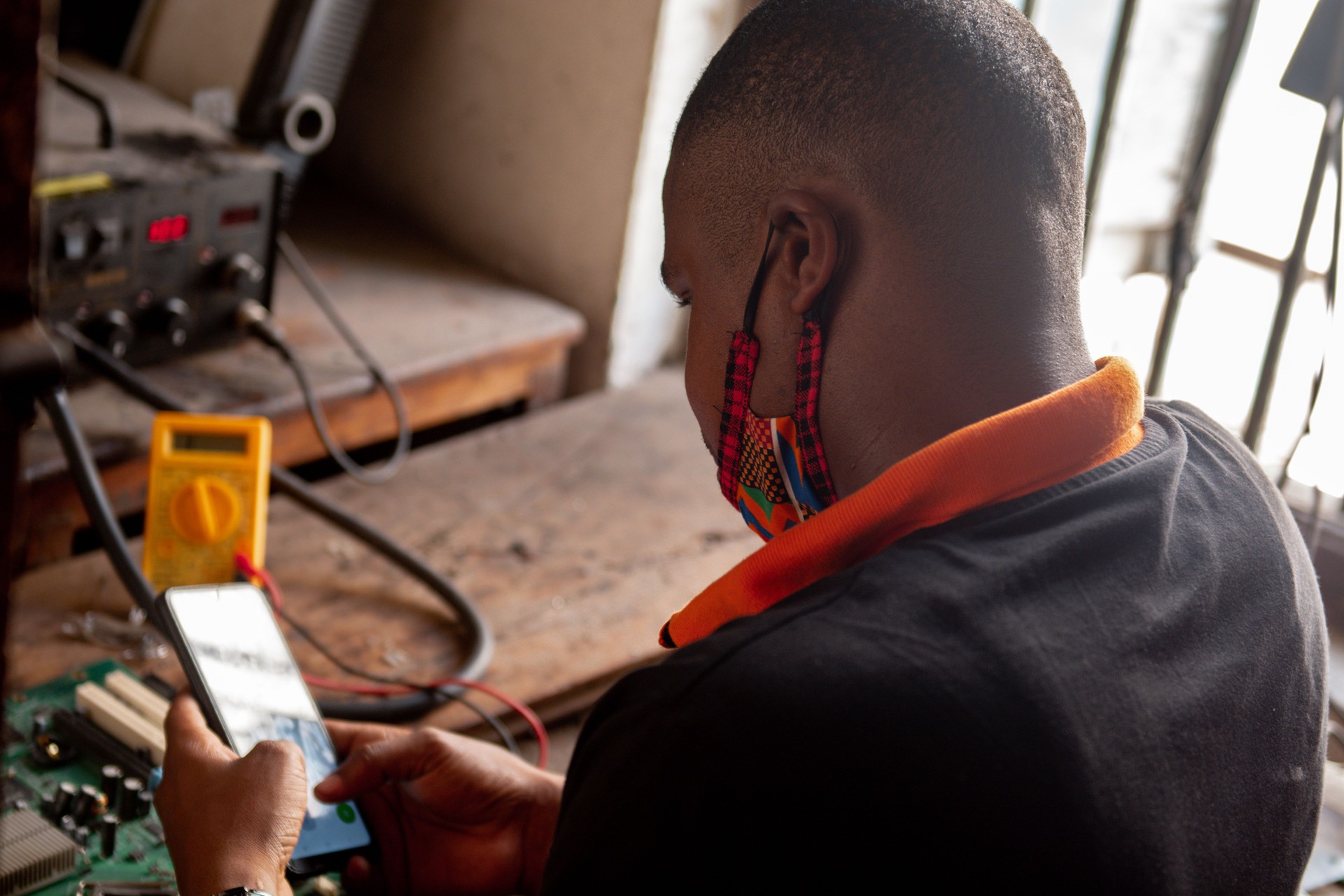 Young Adult Using A Mobile Phone In A Workshop